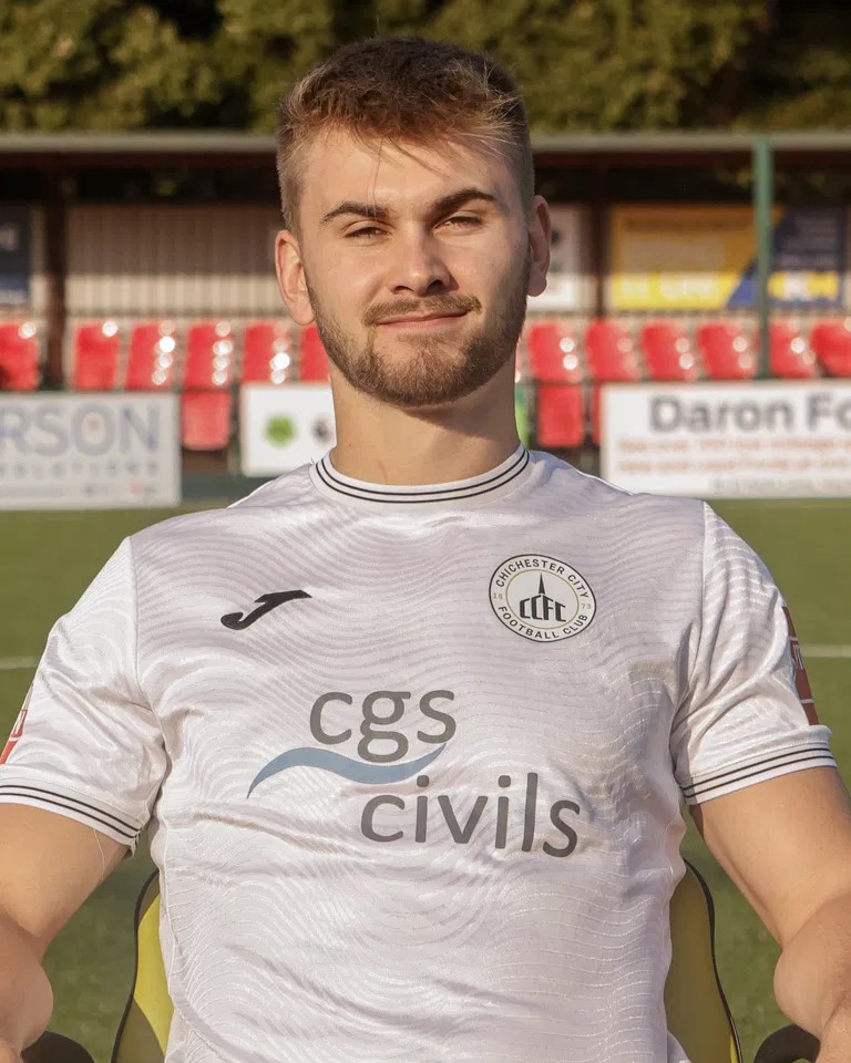 Billy Vigar wearing a white Chichester City FC football jersey.
