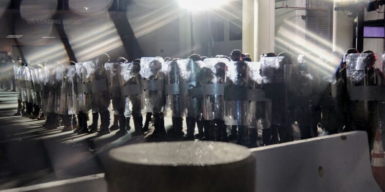 Police in riot gear line up outside the Metropolitan Detention Center in Los Angeles on Sept. 1. Officers confronted demonstrators after hours of anti-ICE protests demanding the abolition of the agency.