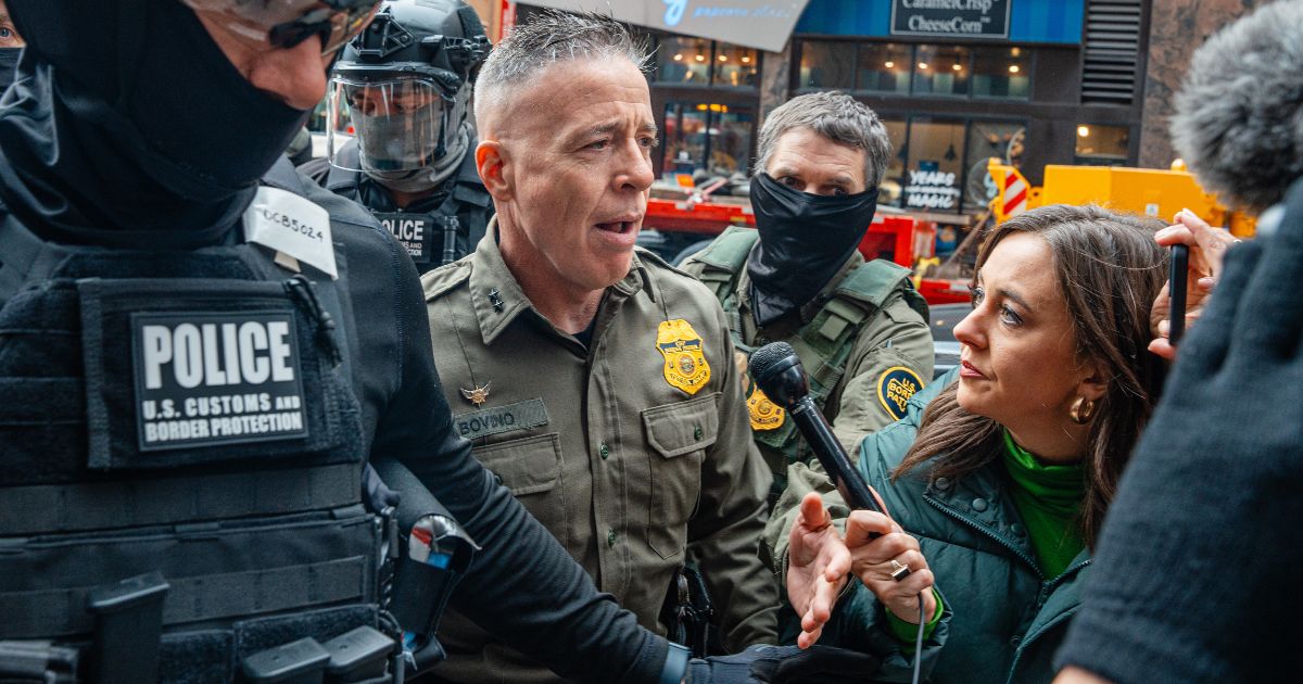 Border Patrol commander Gregory Bovino pushes through a crowd of media and protesters as he enters the Dirksen Federal Building Tuesday in Chicago, Illinois.