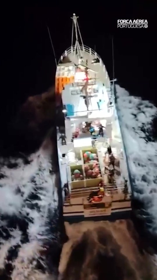 Portuguese Air Force EH-101 Merlin helicopter rescuing five people from a fishing vessel at night.