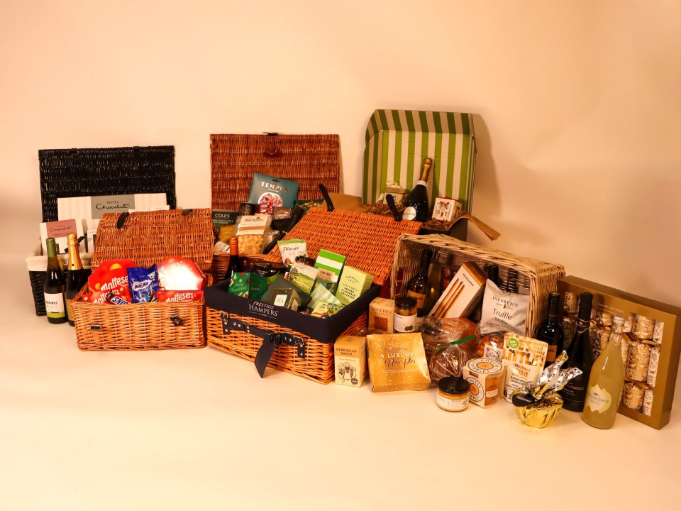 A collection of diverse Christmas hampers filled with various food and drink items.