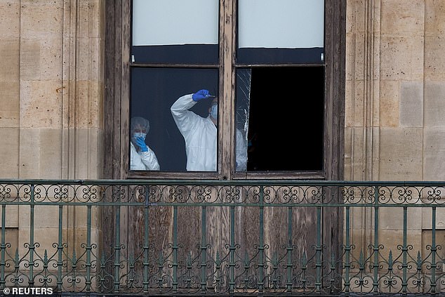 Forensics teams inspect a window to the Apollo Gallery, believed to have been pierced by a disc cutter