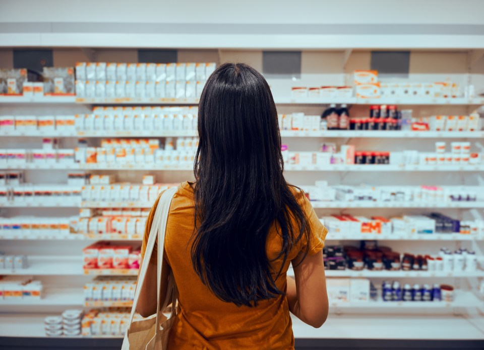 Woman looking at pharmacy shelves.