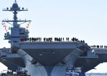 In this handout photo provided by the U.S. Navy, sailors aboard the aircraft carrier Pre-Commissioning Unit Gerald R. Ford man the rails as the ship departs Huntington Ingalls Industries Newport News Shipbuilding for builder's sea trials off the U.S. East Coast on April 8, 2017, in Newport News, Virginia.