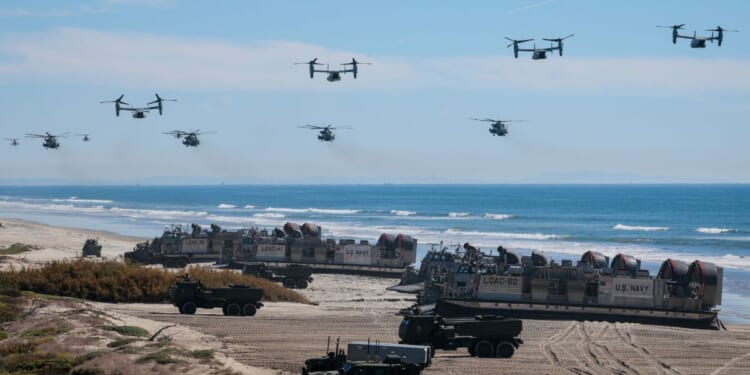U.S. Navy Landing Craft Air Cushions unload equipment onto the beach as U.S. Marine Corps V-22 Ospreys and CH-53 Super Stallions fly overhead during the America's Marines 250 event at Camp Pendleton's Red Beach on Oct. 18, 2025, in Oceanside, California.