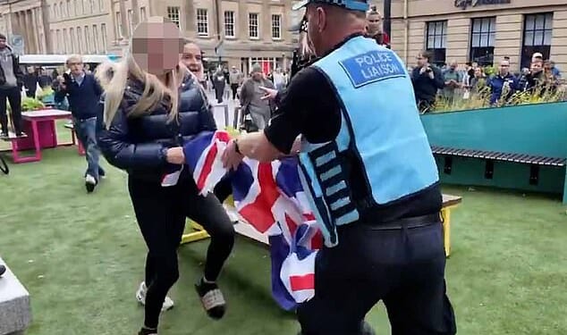 Footage posted on social media shows the Police Liaison Officer snatching the Union Jack flag from the 16-year-old girl's hands