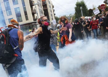 Federal agents, including members of the Department of Homeland Security, the Border Patrol, and police, clash with protesters outside a downtown U.S. Immigration and Customs Enforcement facility Saturday in Portland, Oregon.