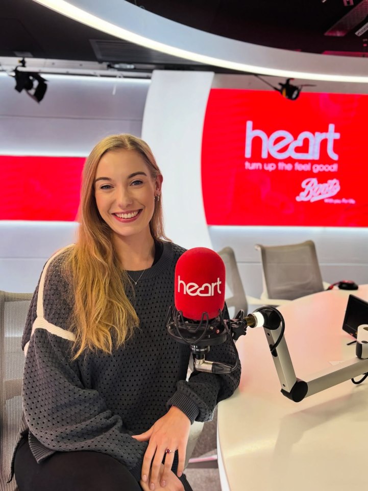 Woman sitting in a radio studio with a Heart FM microphone.