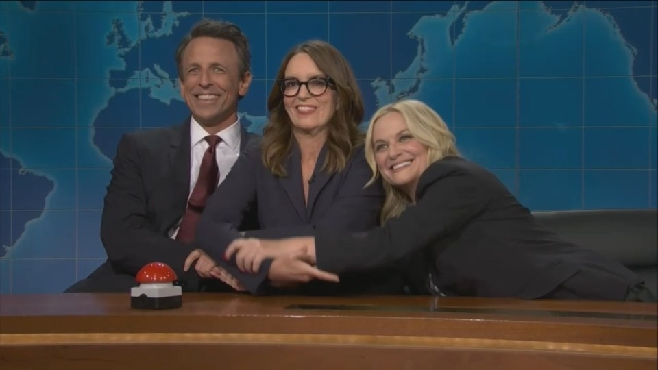 Amy Poehler, Tina Fey, and Seth Meyers at the SNL Weekend Update desk.