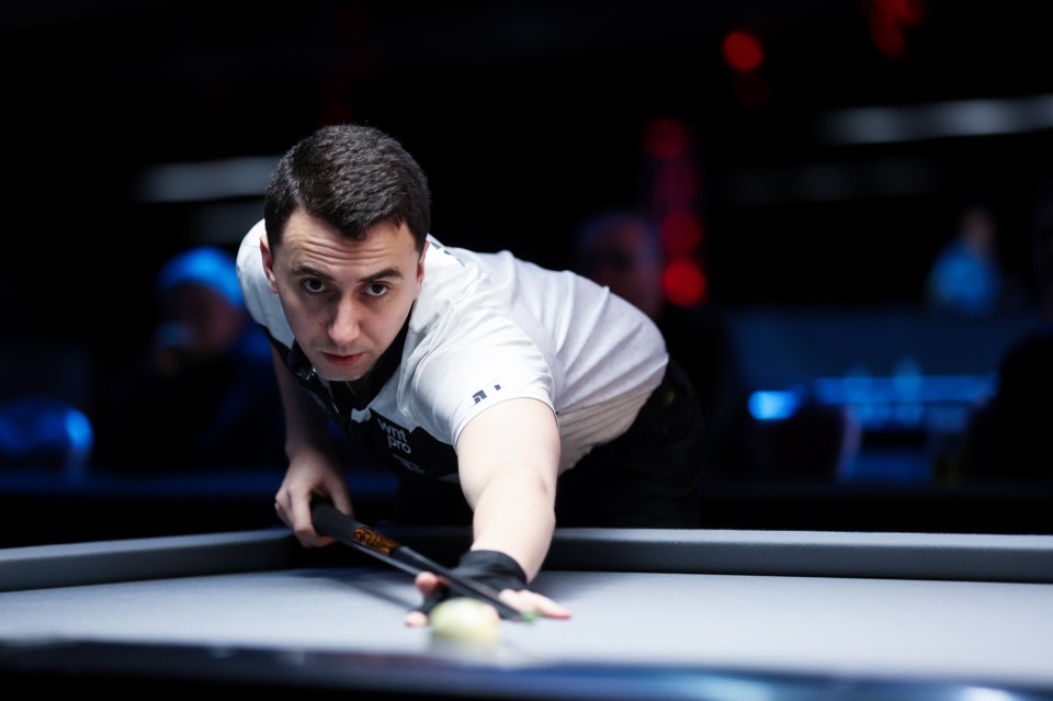 Fedor Gorst holding a trophy and medal, making a peace sign after winning the World Pool Championship.