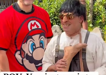 David Habour stops for a picture with a fan while wearing a red Mario T-shirt during a day out at the Epic Universe theme park in Orlando, Florida, with Lily Allen's daughters