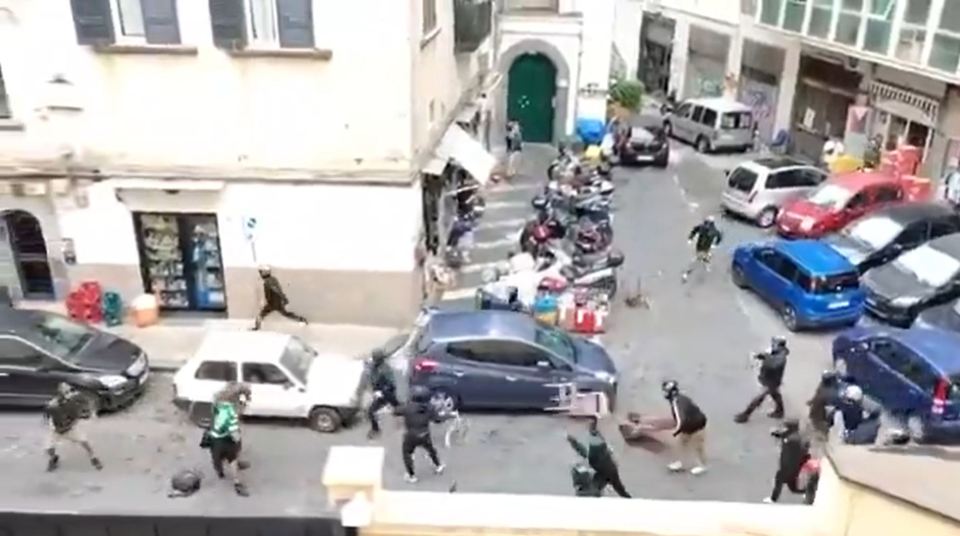 Football fans brawl in the street.