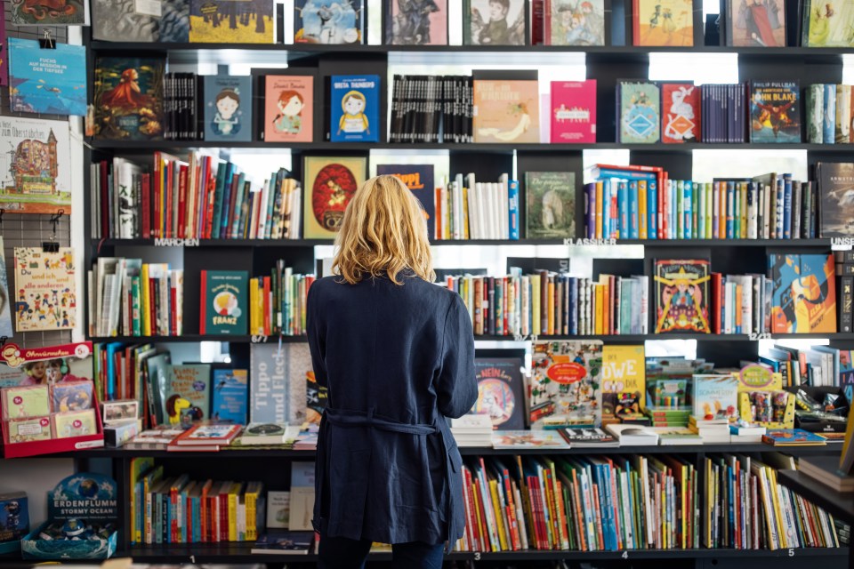 Rear view of a woman looking at books in a bookstore.