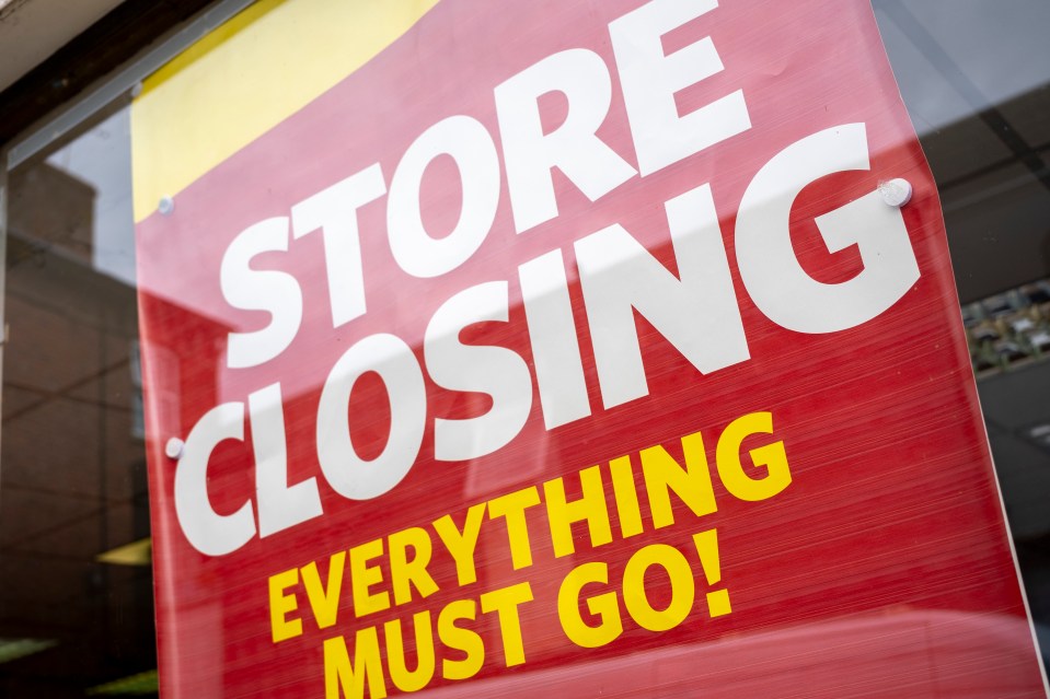 A red sign with white and yellow lettering that reads, "STORE CLOSING EVERYTHING MUST GO!" on the window of a Hallmark & Thorntons store in Leominster, United Kingdom.