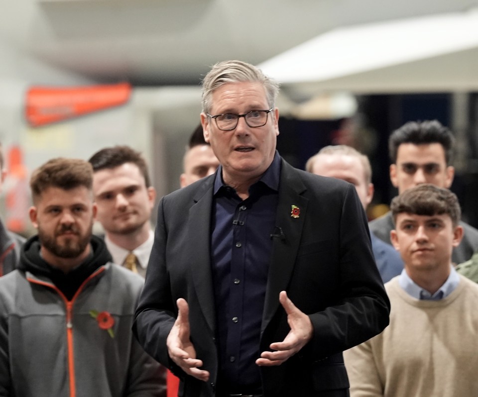 Prime Minister Sir Keir Starmer speaking to workers at BAE Systems with a Typhoon fighter jet in the background.