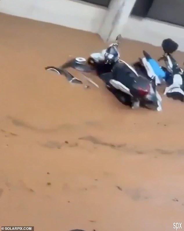 A row of motorbikes were seen almost entirely submerged in muddy water in Ibiza Town