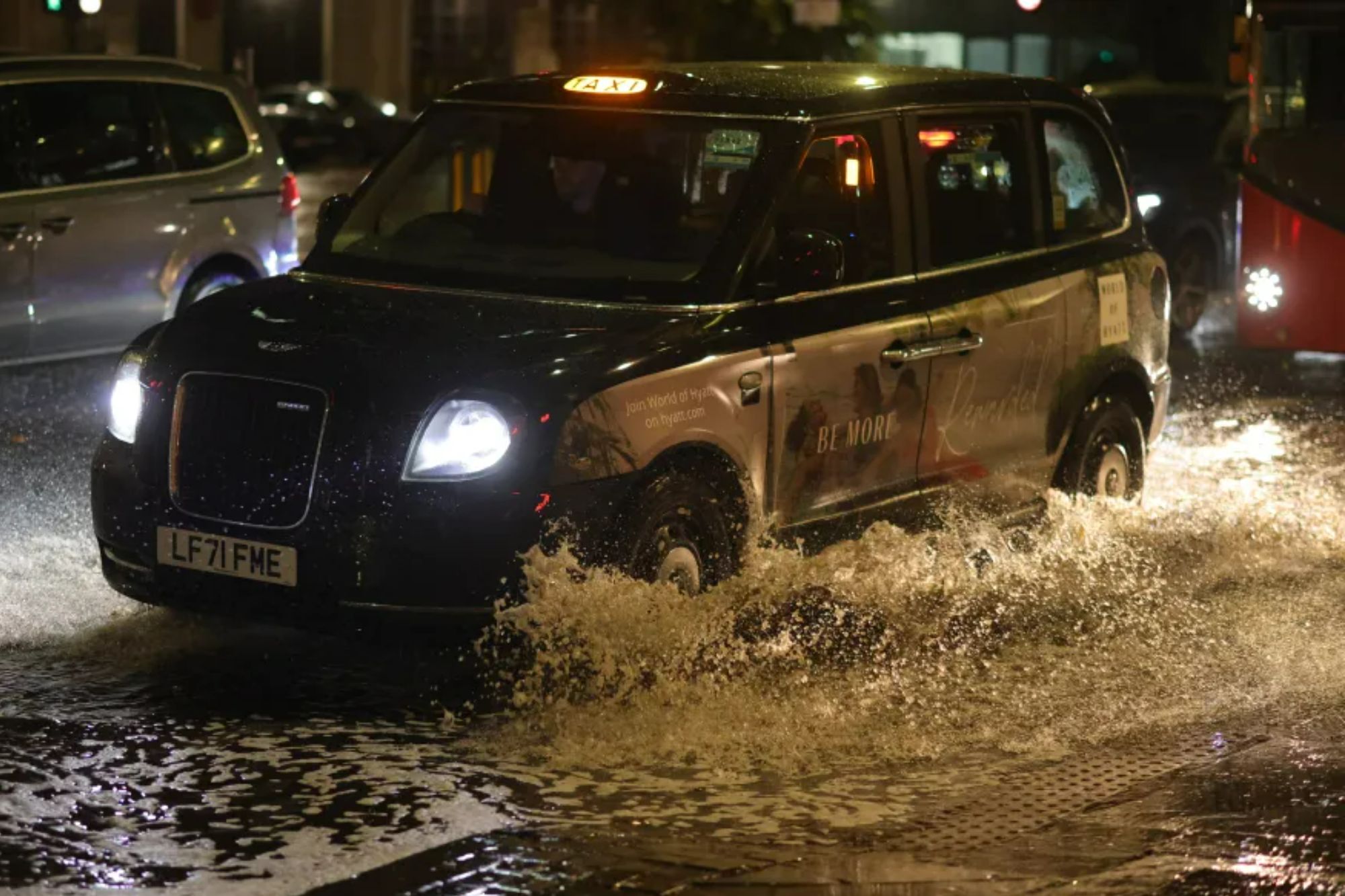 An image collage containing 1 images, Image 1 shows A black London taxi driving through a flooded street, making a large splash