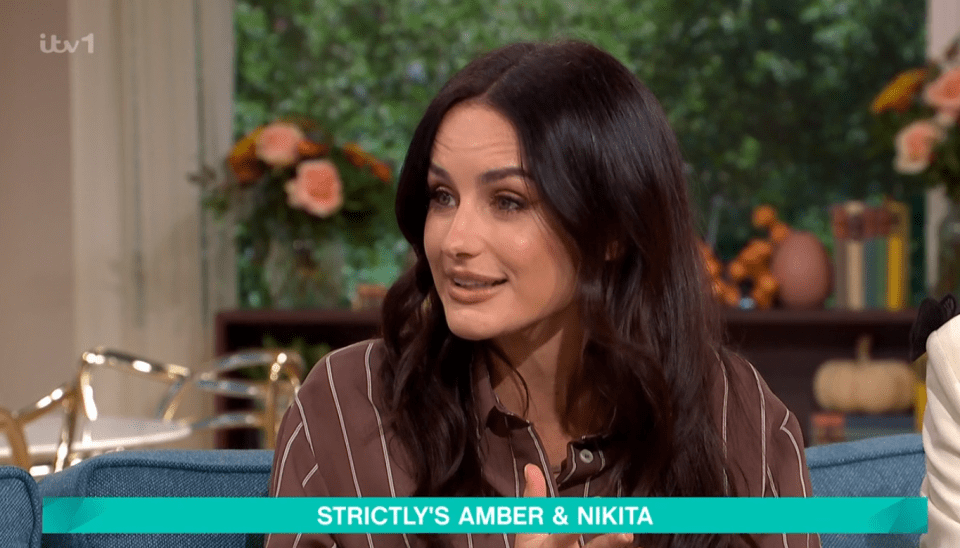 Amber Davies talking on This Morning, with text "STRICTLY'S AMBER & NIKITA" at the bottom of the screen.
