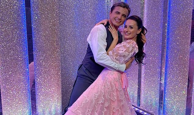 Strictly professional Nikita Kuzmin and his celebrity partner Amber Davies have 'sizzling chemistry' after he was spotted kissing her head in the street
