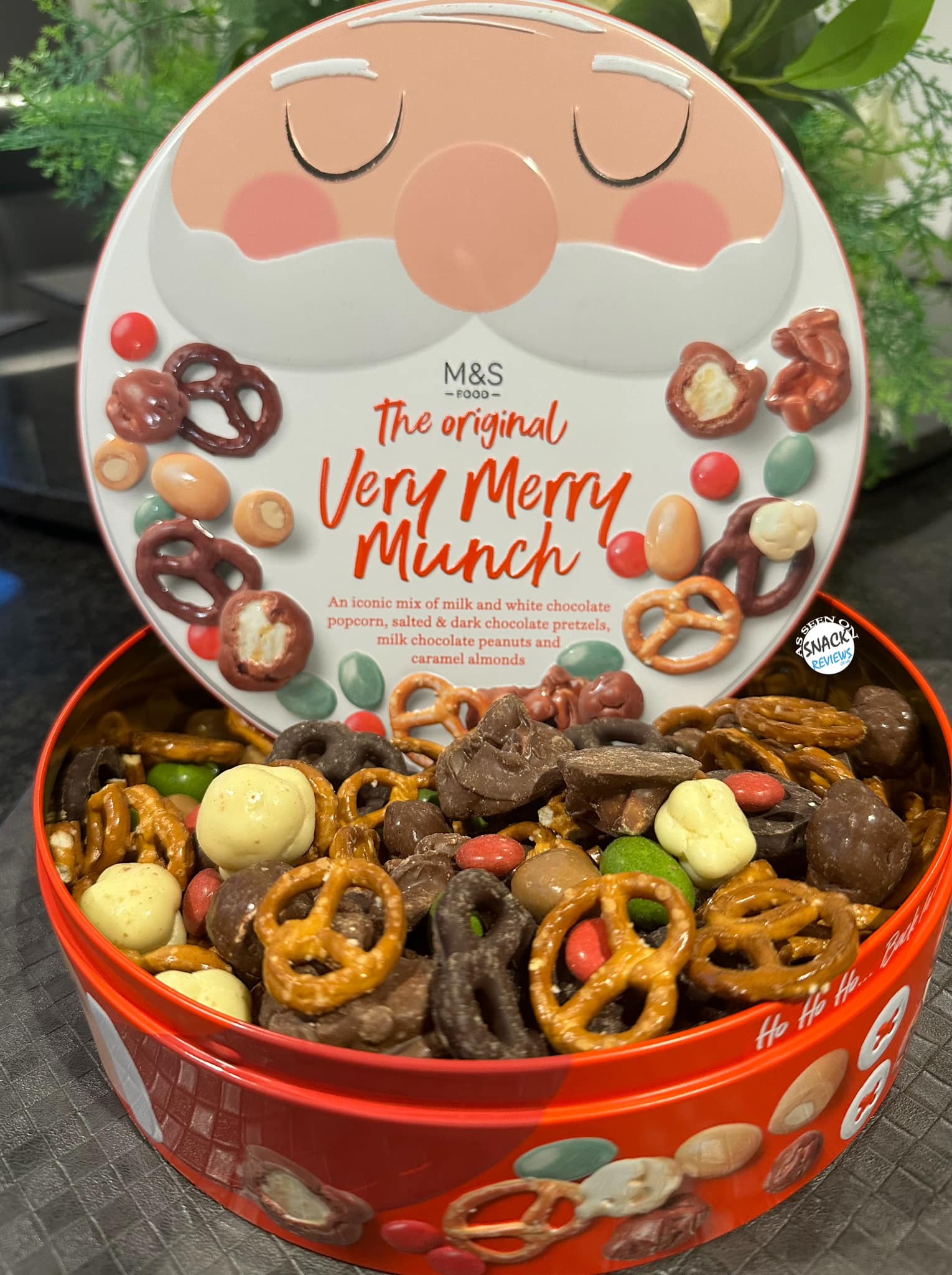 M&S Very Merry Munch Mix in a Santa-themed tin.