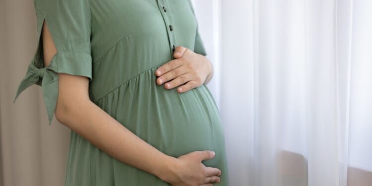 A pregnant woman holds her belly and prepares for childbirth.