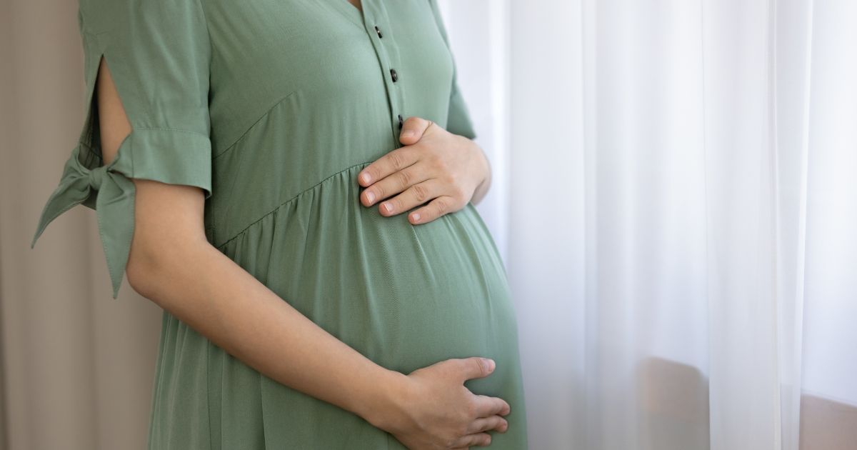 A pregnant woman holds her belly and prepares for childbirth.