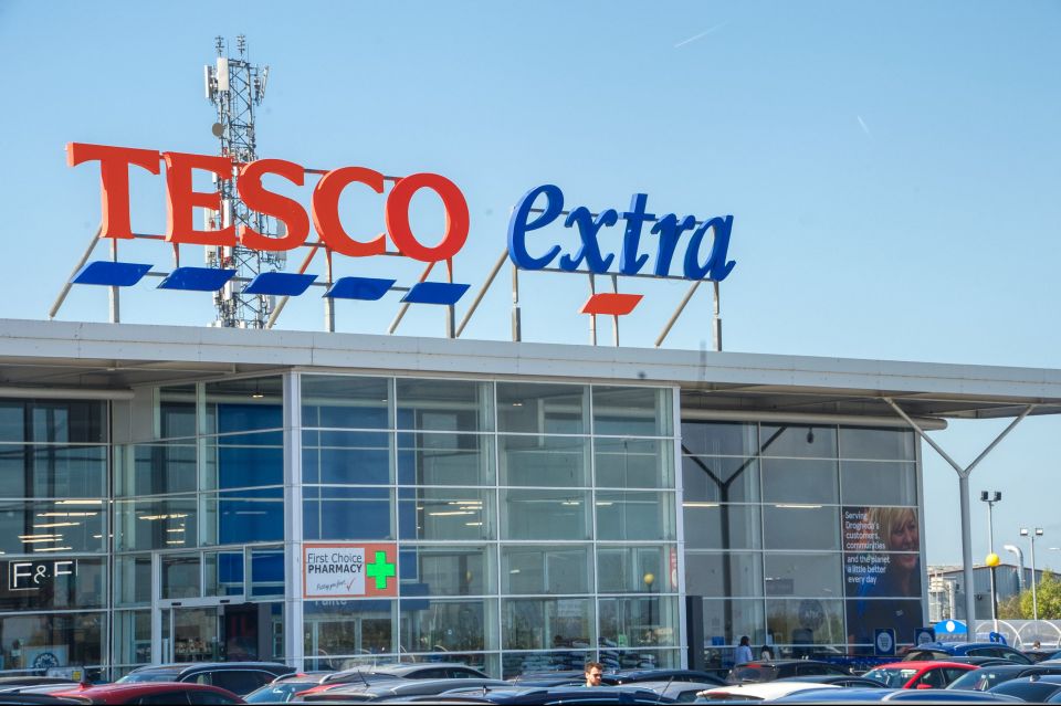 A Tesco Extra store with a First Choice Pharmacy and F&F clothing section, and a sign proclaiming "Serving Drogheda's customers, communities and the planet a little better every day."