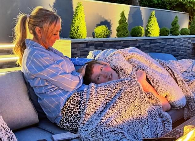 Claire is pictured with Aiden cuddling on an outdoor sofa - her and Paul share custody