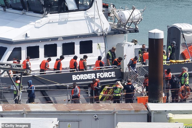 Migrants are brought ashore at Dover yesterday after being intercepted in the Channel