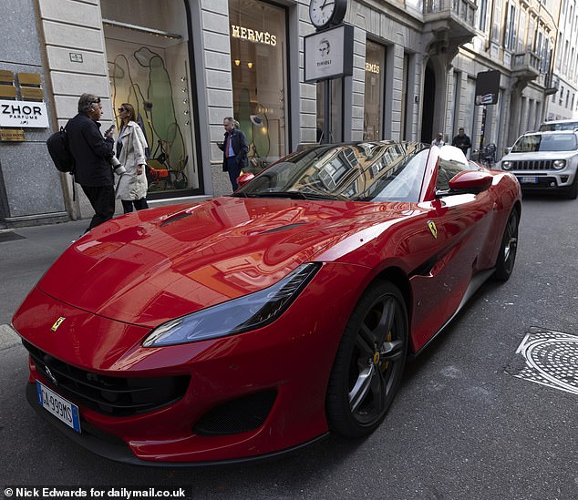 A red Ferrari parked in Quadrilatero Della Moda, a high-end shopping area in Milan shows off the area's wealth. Italy offers generous tax perk for foreigners and eight years ago ditched complex rules in favour of a single annual tax payment capped at £174,000