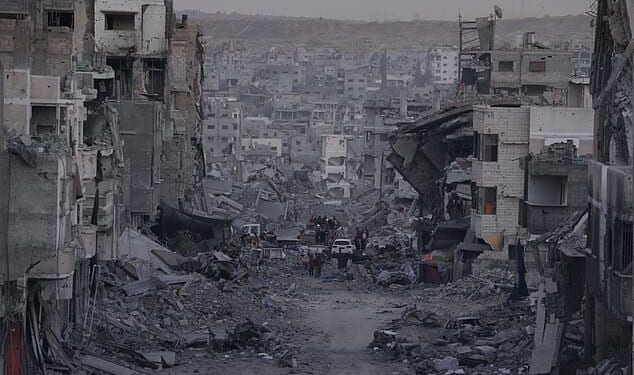 Palestinians walk among destroyed buildings in Gaza City on Sunday, October 12