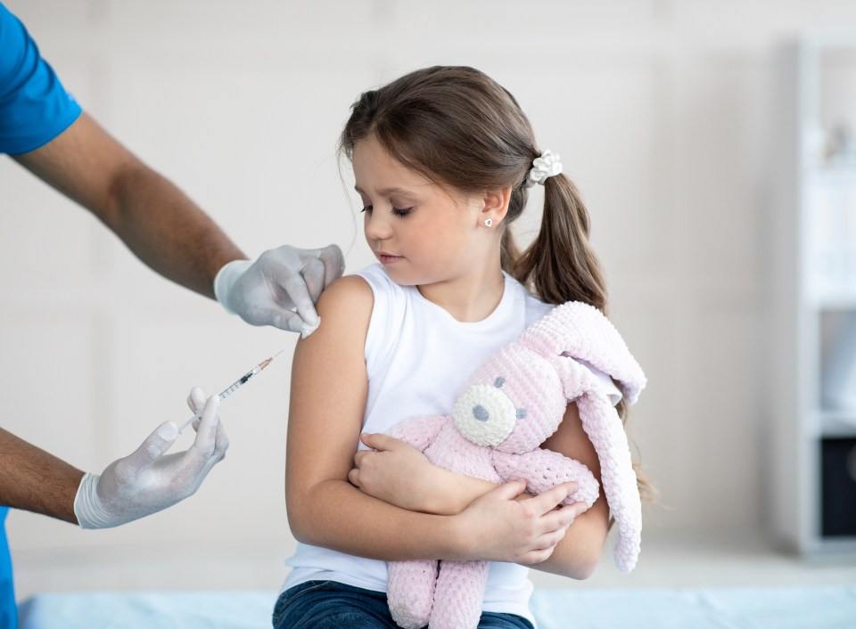 Doctor giving a little girl a COVID-19 vaccine.