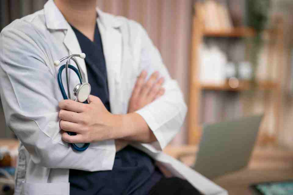 Doctor holding a stethoscope in a hospital setting.
