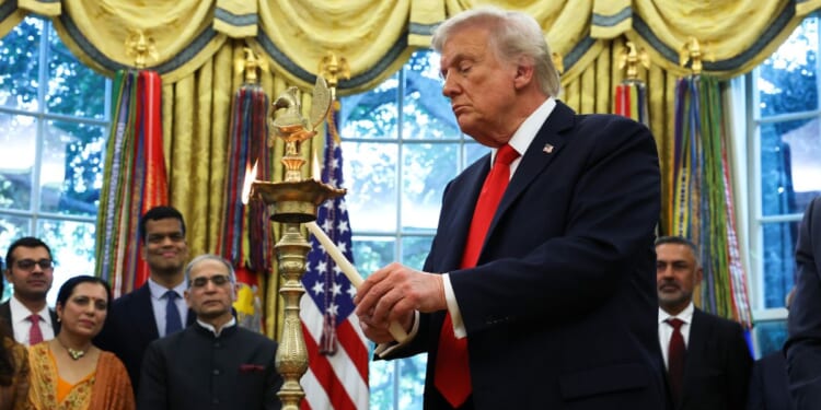 President Donald Trump lights a diya candle during an event celebrating Diwali in the Oval Office of the White House in Washington, D.C., on Tuesday.