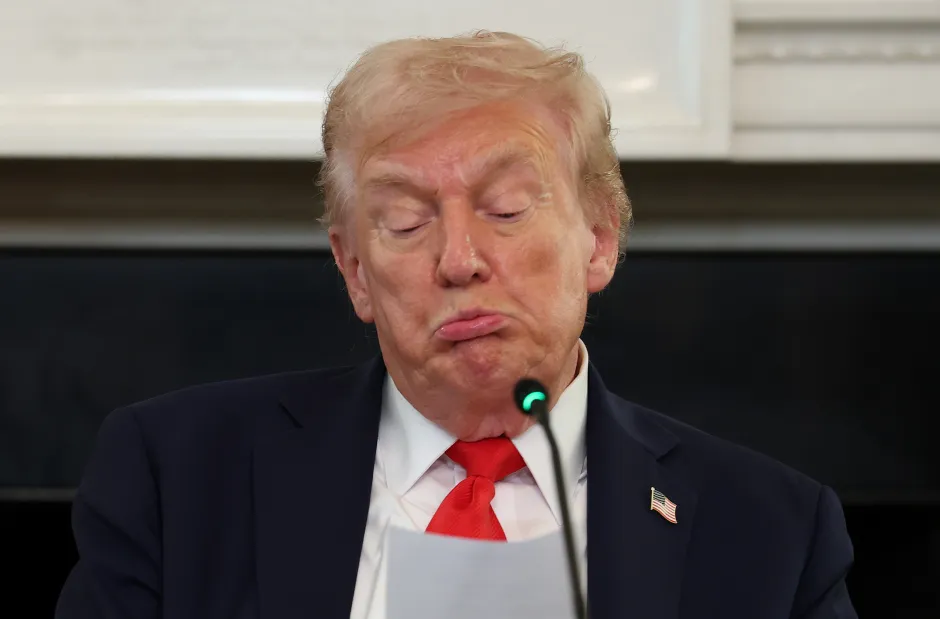 Donald Trump making a pouting face at a microphone.