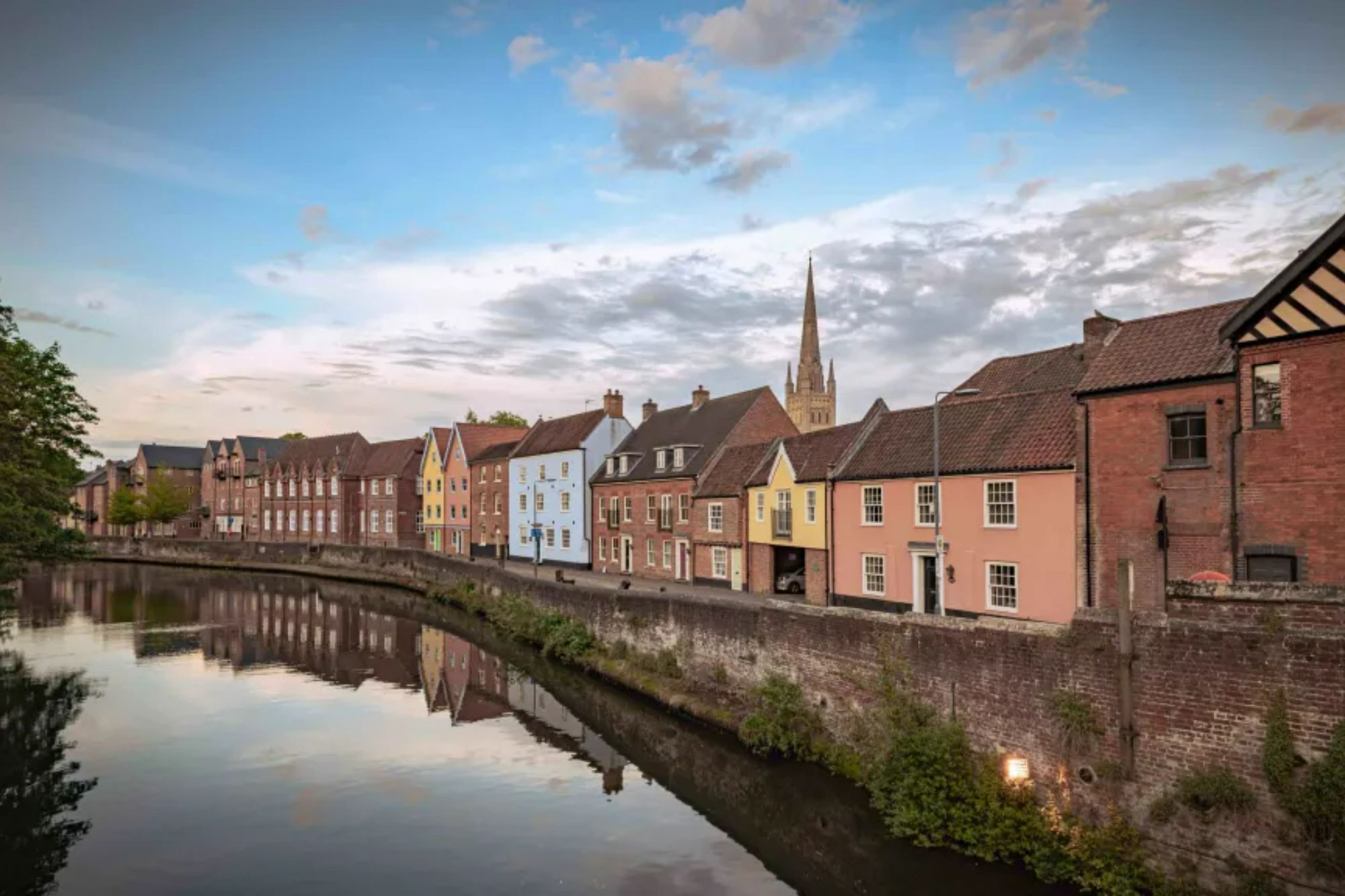 An image collage containing 1 images, Image 1 shows Colorful houses line a river, with a church steeple visible in the background