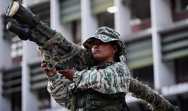 A member of the Bolivarian Militia holds a weapon during a rally amid rising tensions with the United States, in Caracas, Venezuela, on Thursday