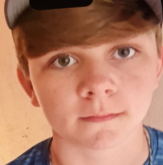 A close-up of Cayden Sweeney, a 14-year-old boy with blonde hair and green eyes.