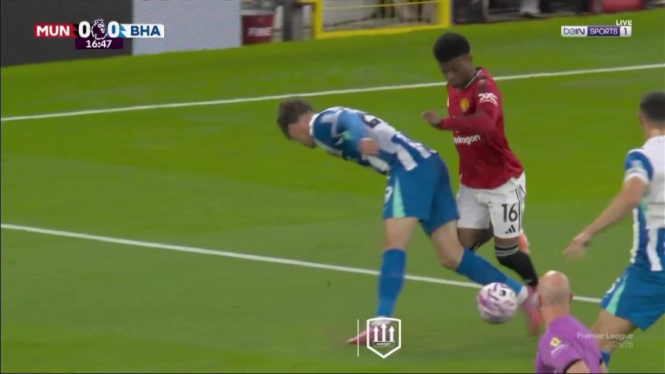A soccer player in a red jersey attempts to steal the ball from a player in a blue and white jersey.