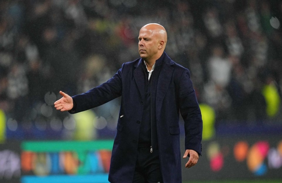 Liverpool FC manager in a dark coat gesturing during a UEFA Champions League match.