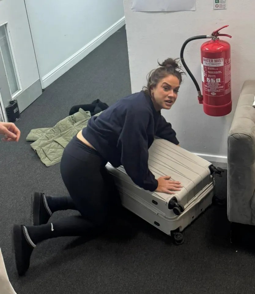 Vicky Pattison on her knees next to a suitcase.