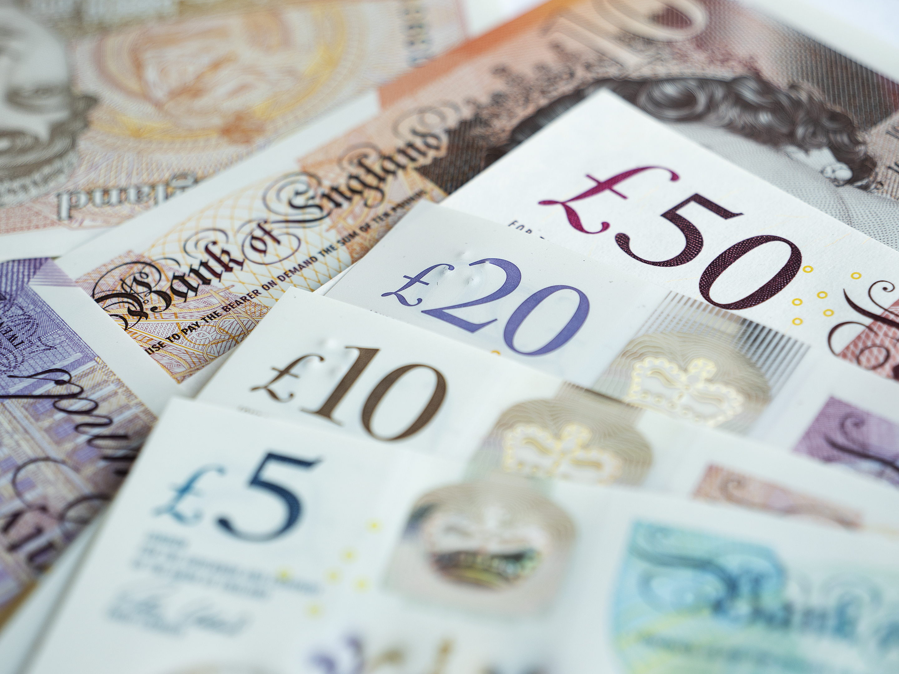 Close-up of British bank notes, including £5, £10, £20, and £50 denominations.