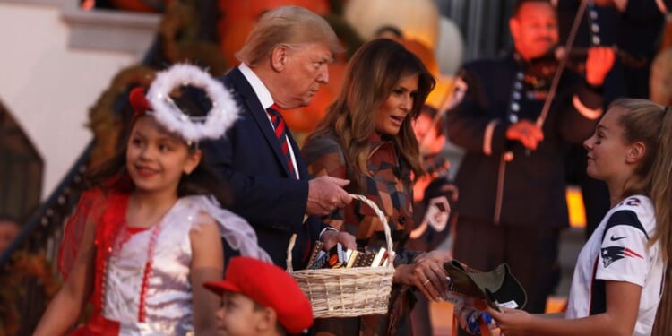 President Donald Trump and First Lady Melania Trump hand out candy to children as they trick-or-treat during a Halloween at the White House event at the South Portico of the White House on Oct. 28, 2019, in Washington, D.C.