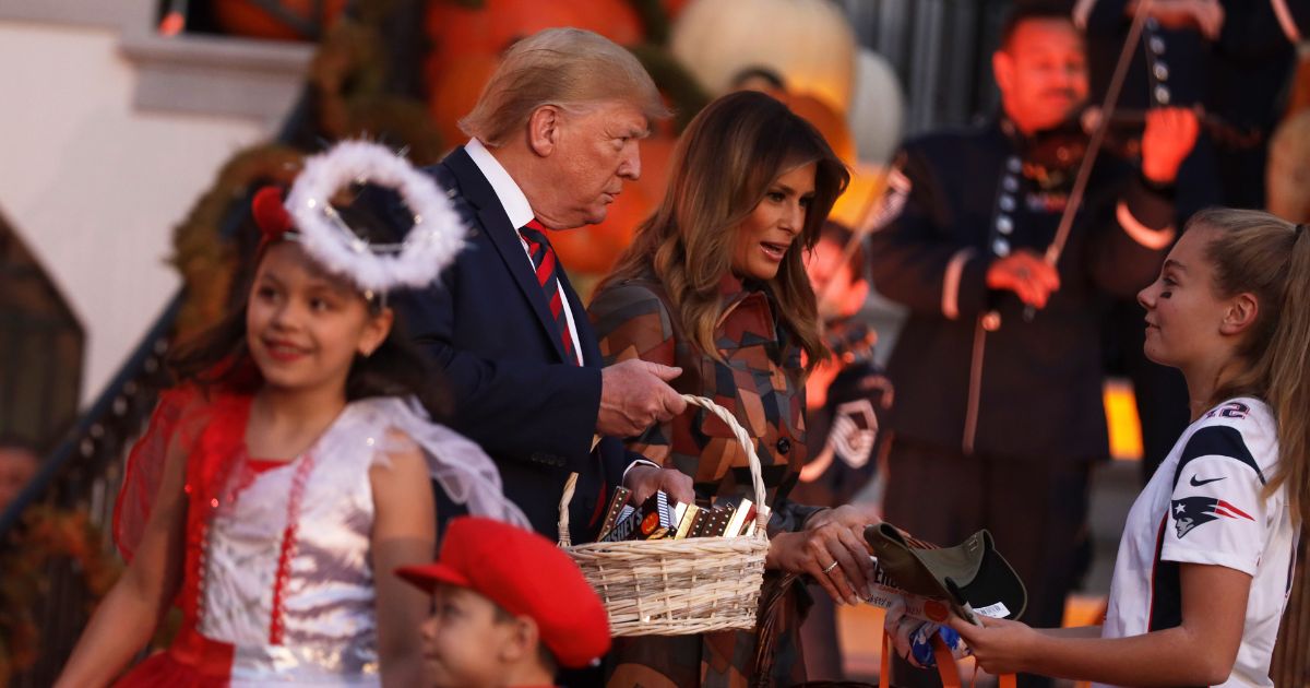 President Donald Trump and First Lady Melania Trump hand out candy to children as they trick-or-treat during a Halloween at the White House event at the South Portico of the White House on Oct. 28, 2019, in Washington, D.C.