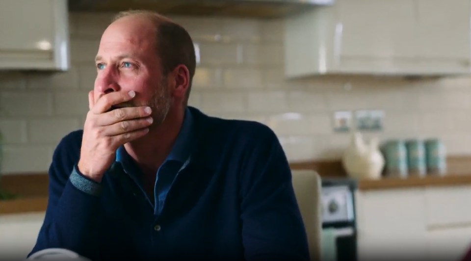 Prince William covers his mouth with his hand.