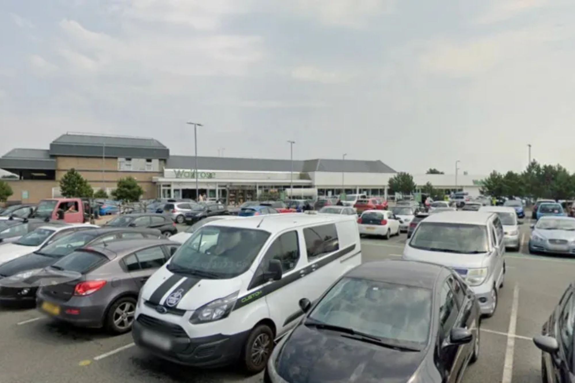 An image collage containing 1 images, Image 1 shows The exterior of a Waitrose supermarket from a busy parking lot