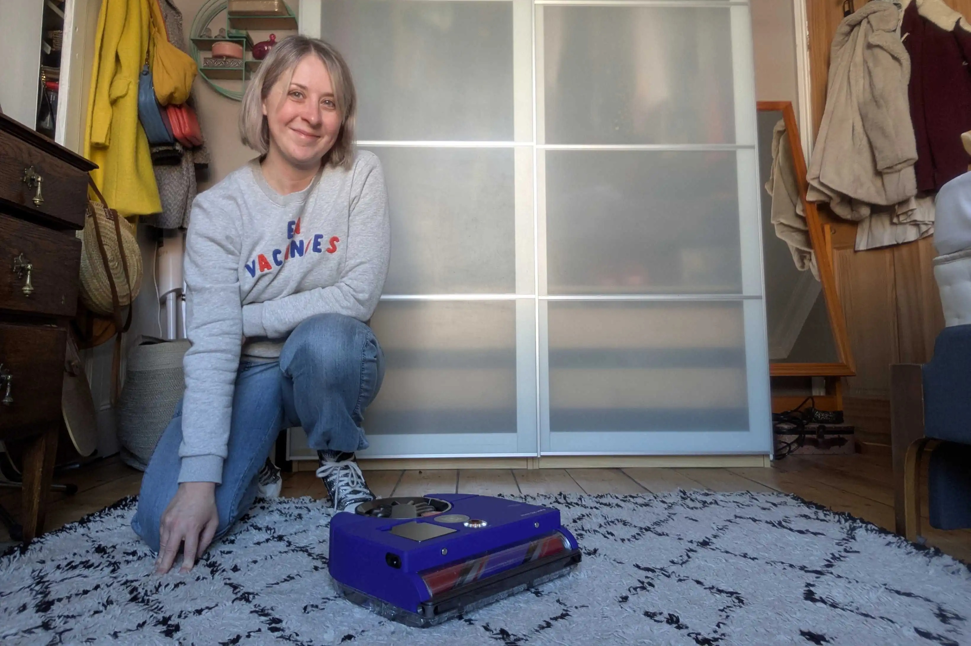 Senior Feature Writer Alex Lloyd kneels next to the Dyson 360 Vis Nav