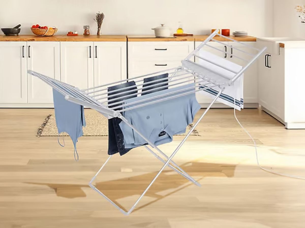 Electric clothes drying rack with clothes hanging on it in a kitchen.