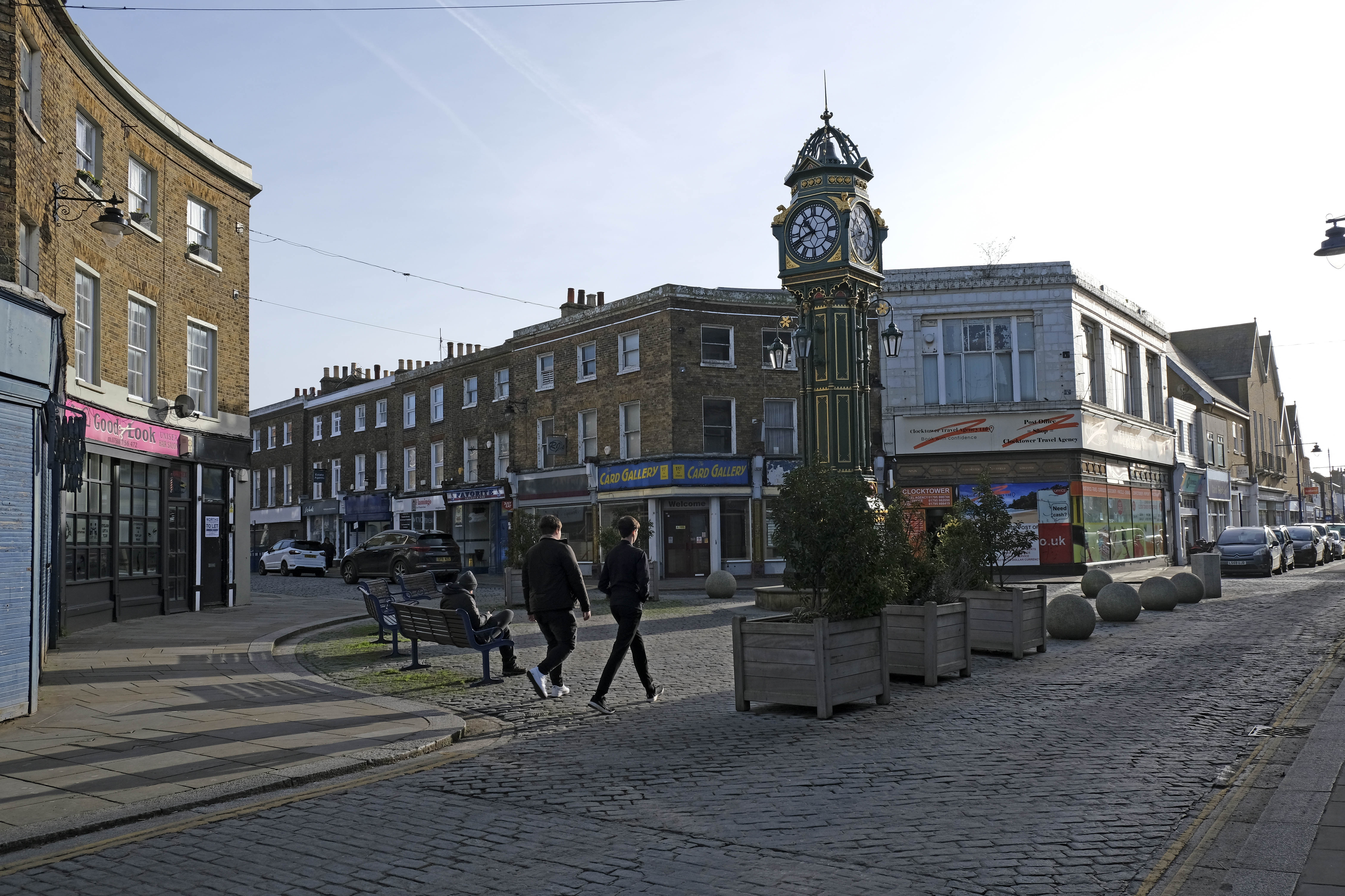 A general view of the High Street in Sheerness, Isle of Sheppey, Kent, UK, with a clock tower and buildings with shops.
