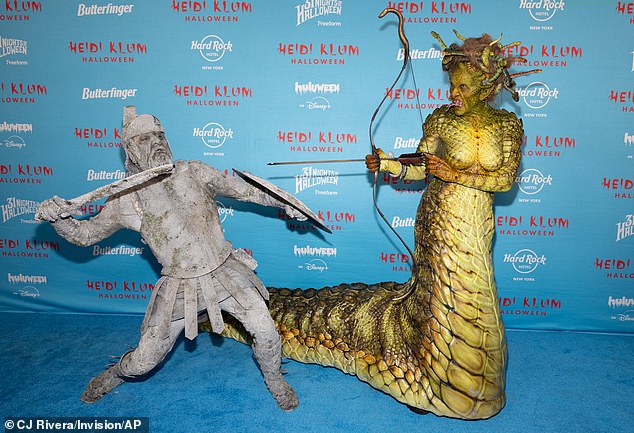 As Heidi and Tom walked the red carpet, he adopted a variety of poses in which his character was turned to stone while facing down the monster
